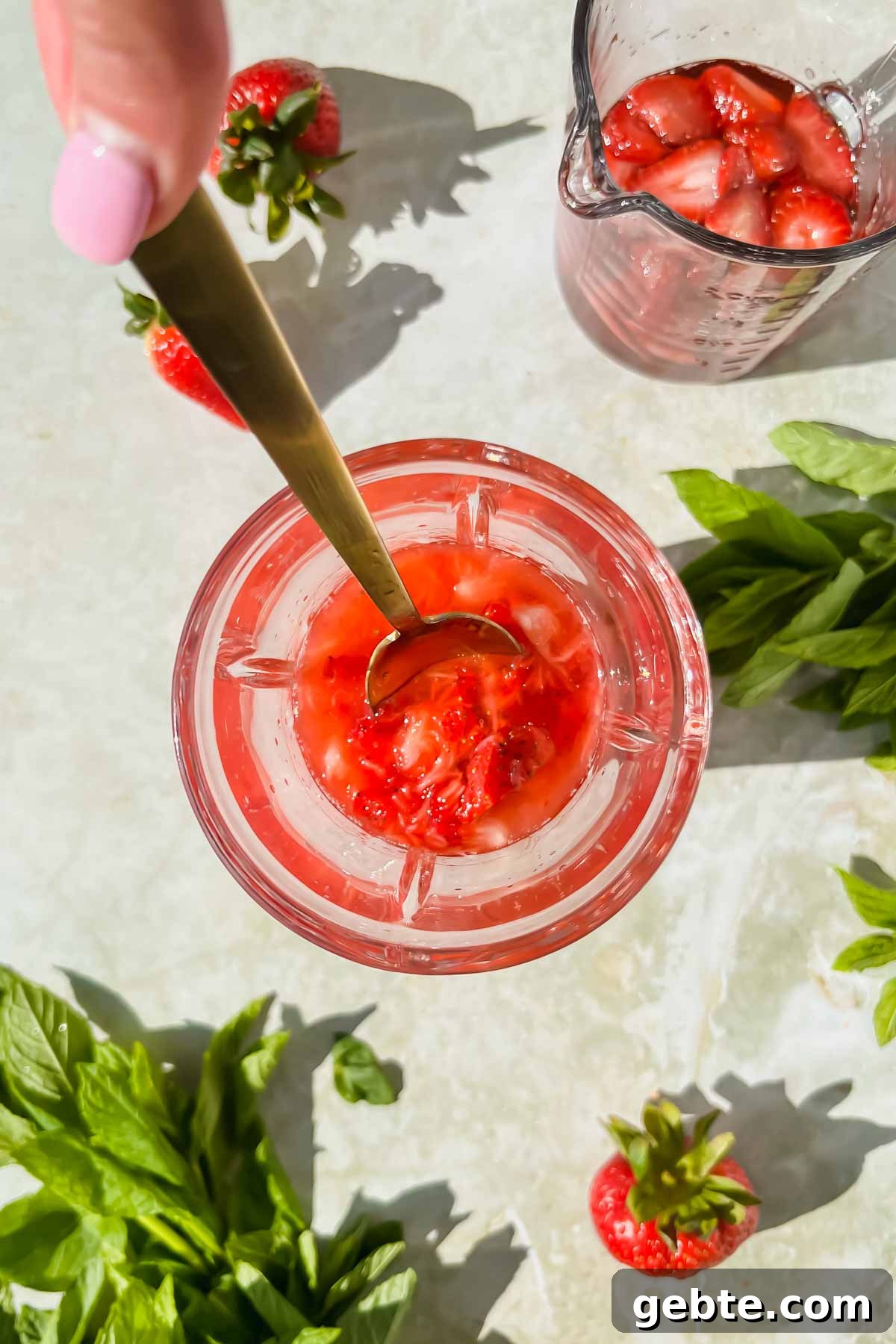 Strawberry Gin Smash: Refreshing Cocktail Recipe for Summer 5 strawberries being mashed in cocktail shaker.
