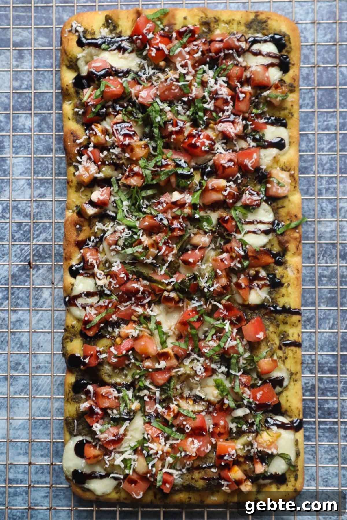 baking rack with bruschetta flatbread topped with cheese and balsamic glaze