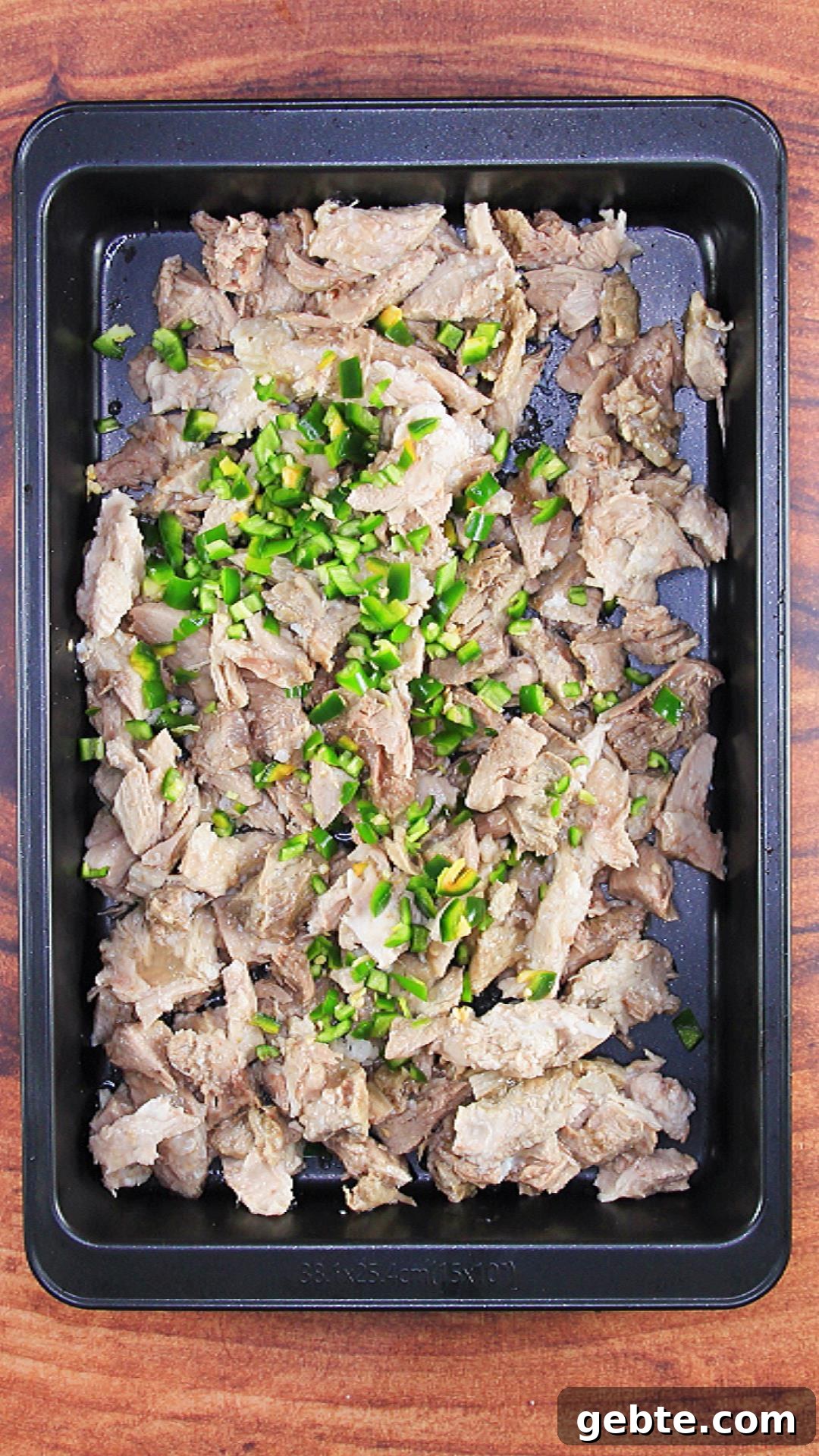 Savory Pulled Pork Green Chile (Chili Verde) Recipe 7 A sheet pan filled with pulled pork and diced green jalapenos - Hostess At Heart