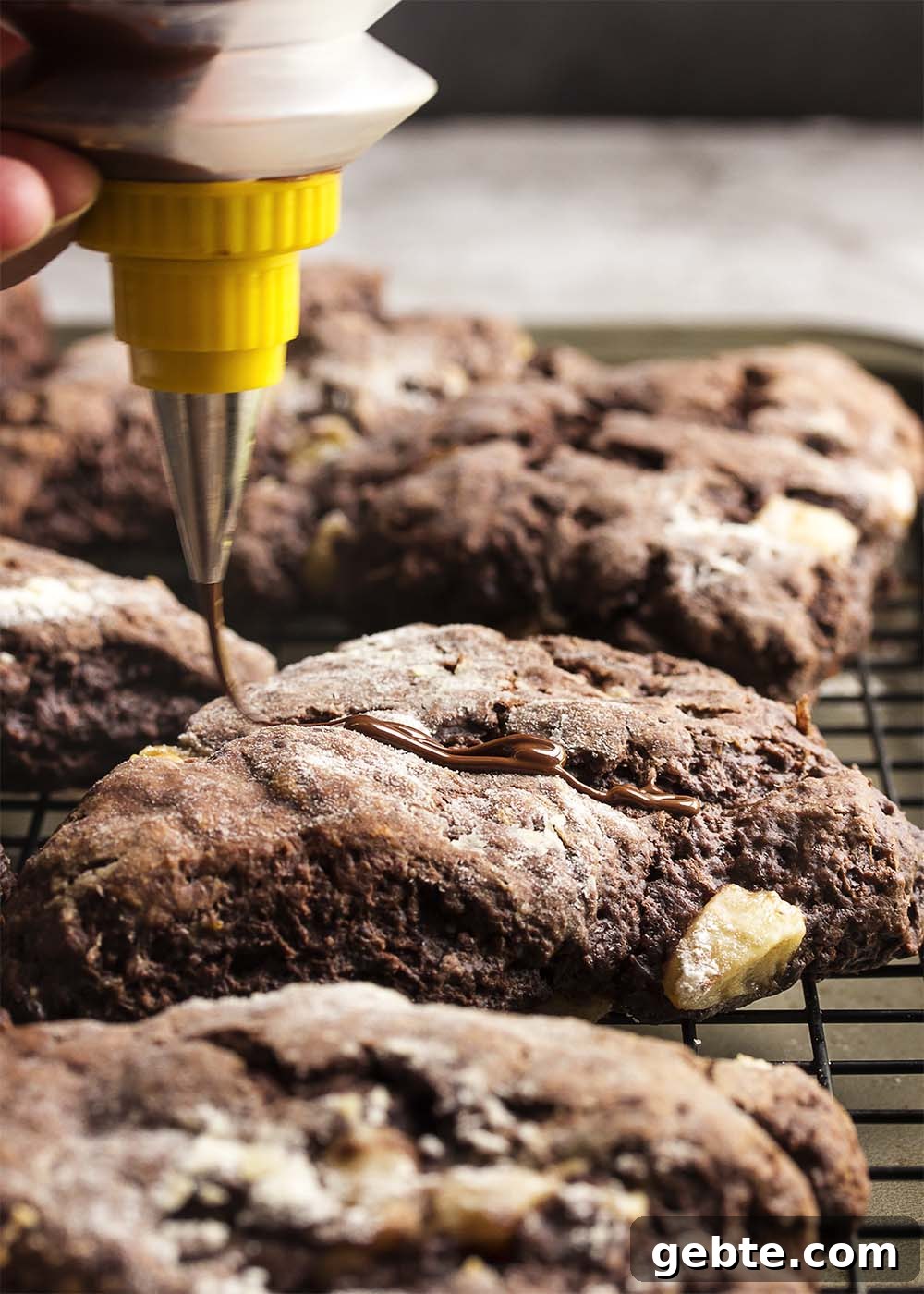 Triple Chocolate Banana Scones - These triple chocolate scones are studded with banana chunks in an intensely chocolatey batter and then topped with chocolate glaze and a peanut butter drizzle. Have them for breakfast or dessert and they would be perfect for a brunch.