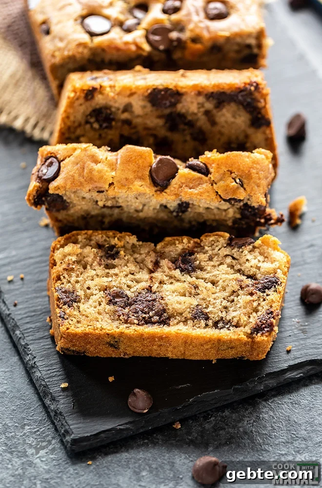 a slice of eggless chocolate chip cake being cut from the main loaf