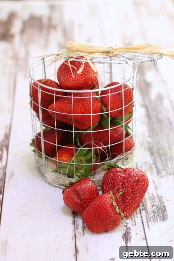 A container of fresh strawberries on a white table