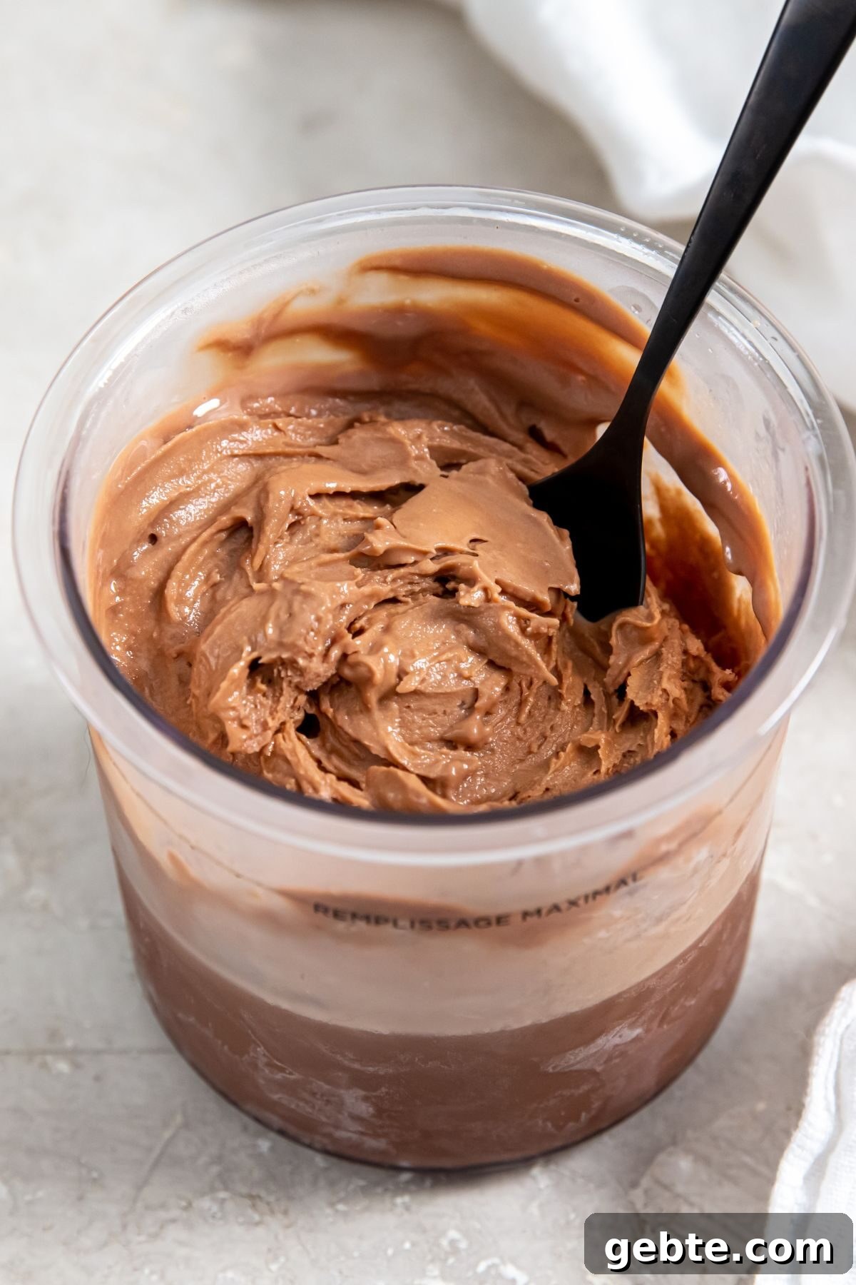 Chocolate protein ice cream without bananas in a clear pint with a black spoon