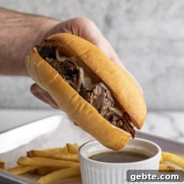 Crock Pot French Dip sandwich over a small bowl with au jus.