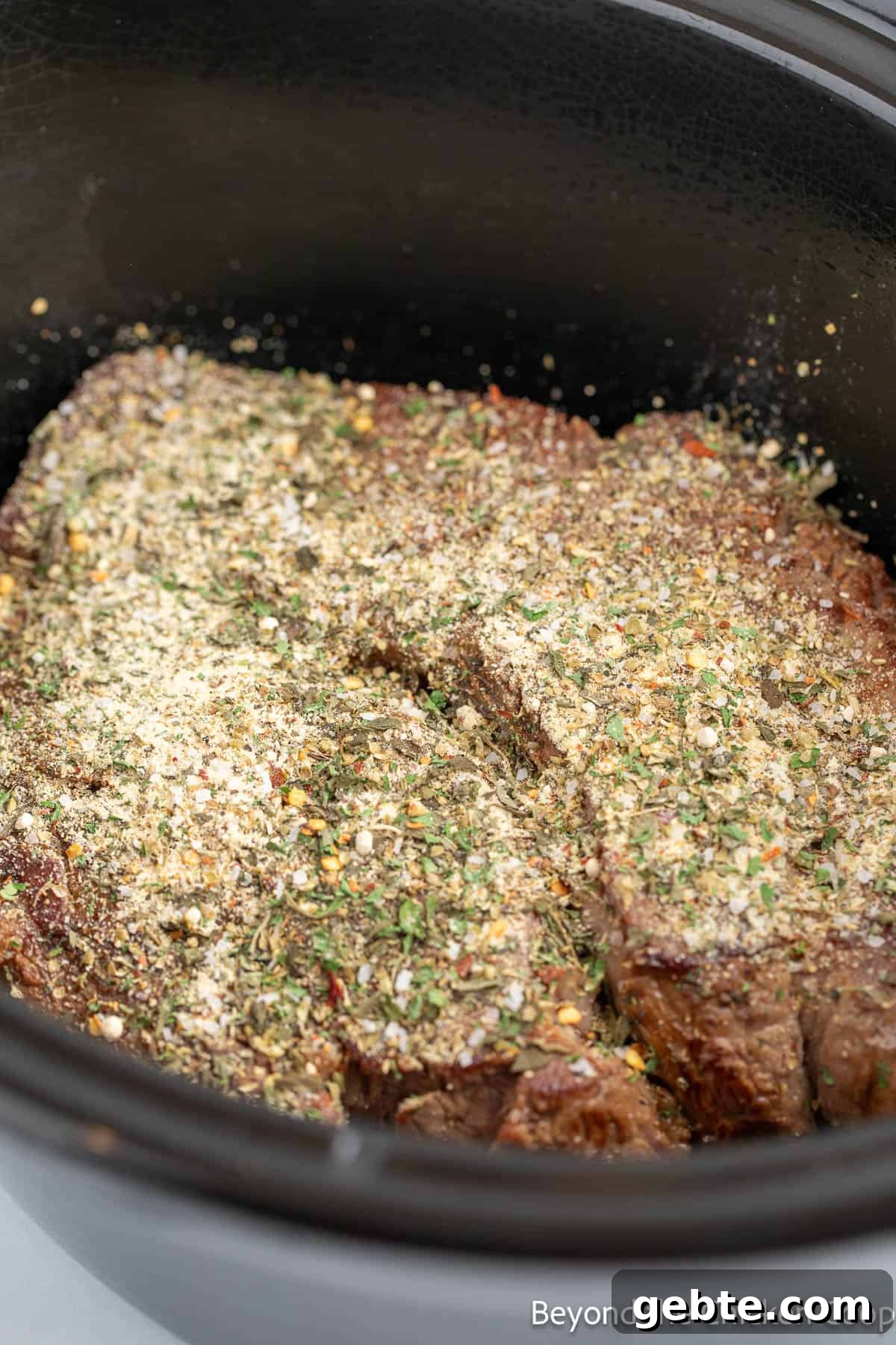 Seasoning a roast in the crockpot. 