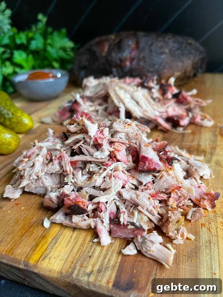How to Smoke Pork Shoulder (Pork Butt) to Tender Perfection 11 Chopped and shredded pork butt on a cutting board.