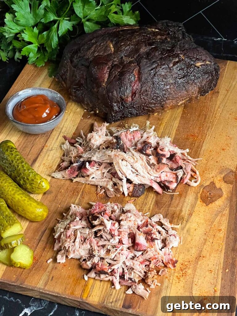 How to Smoke Pork Shoulder (Pork Butt) to Tender Perfection 3 A cutting board with a whole smoked pork butt, shredded smoked pork butt, and chopped smoked pork butt.