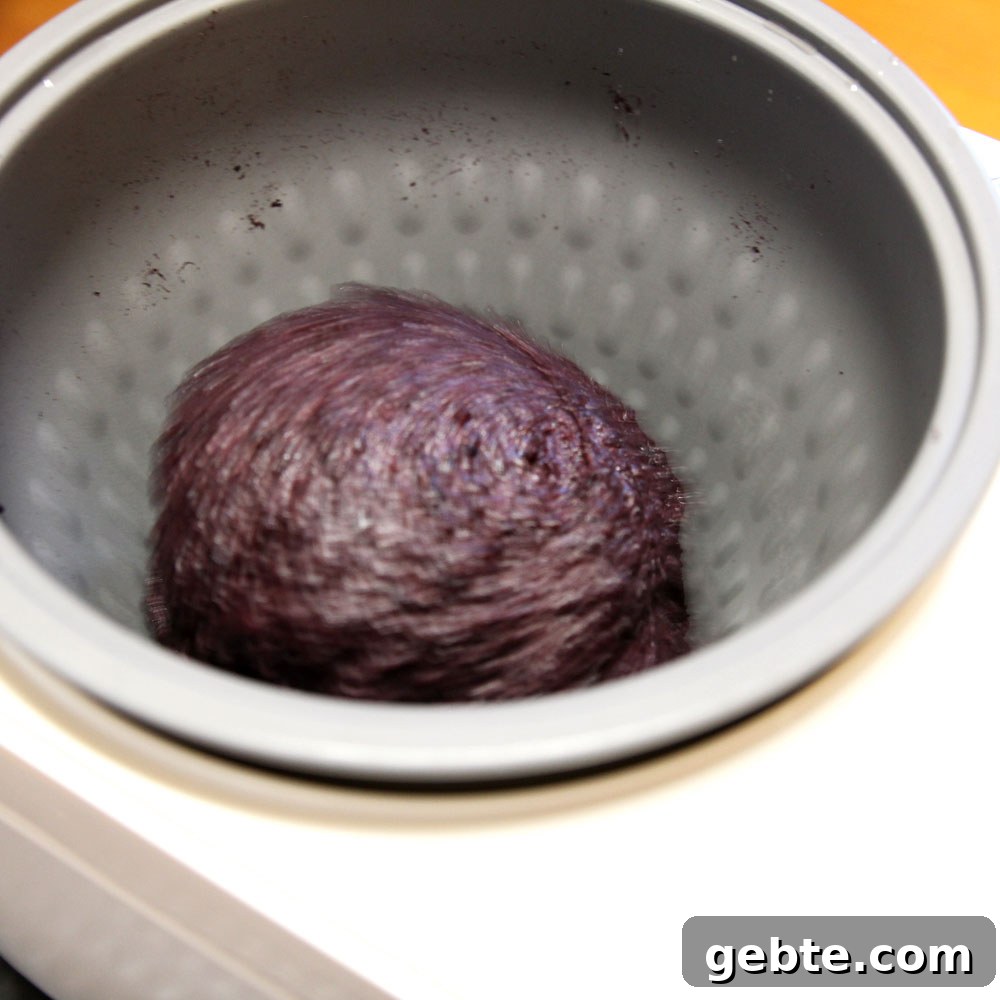 mochi maker will pound the glutinous wild black rice into mochi