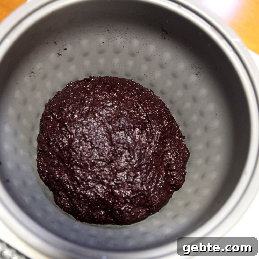 mochi maker will pound the glutinous wild black rice into mochi