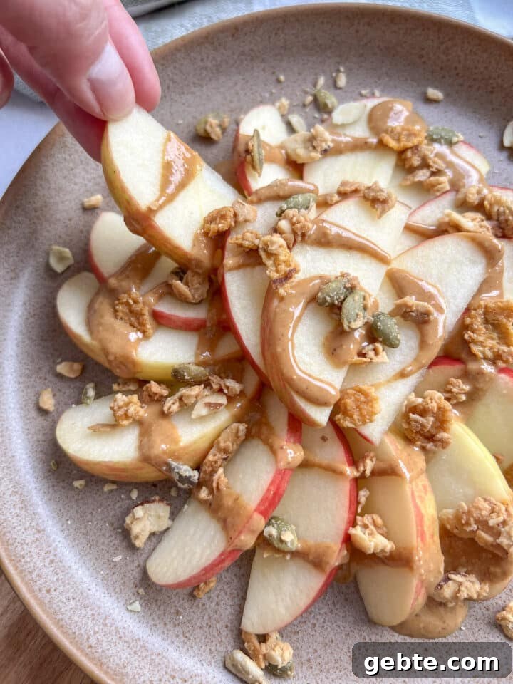 Healthy apple nachos on a plate with peanut butter and granola