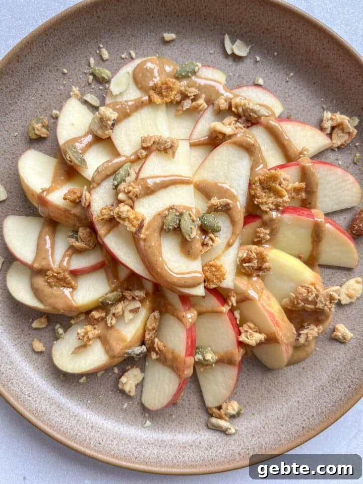 plate of apple nachos topped with peanut butter and granola