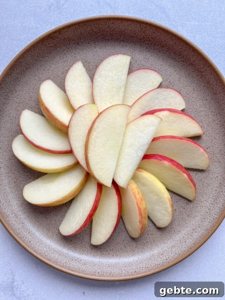 Brown plate with apple slices arranges in a circle.