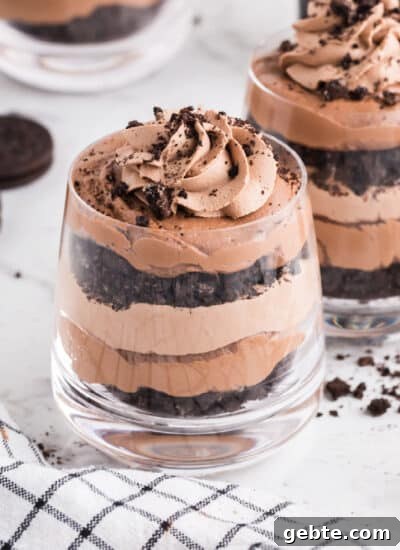 Layers of chocolate cookies, mousse, and Bailey's chocolate cheesecake in glasses.