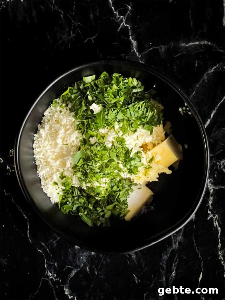 Butter and herbs in a black bowl.