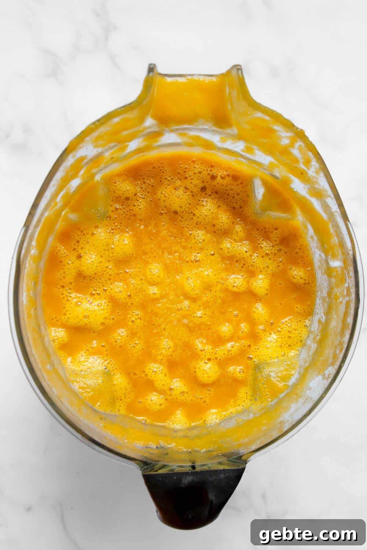 Creamy Carrot & Butternut Squash Soup Recipe for Fall Nights 10 Cooked butternut squash and carrot soup being blended in a high-speed blender until smooth and creamy.