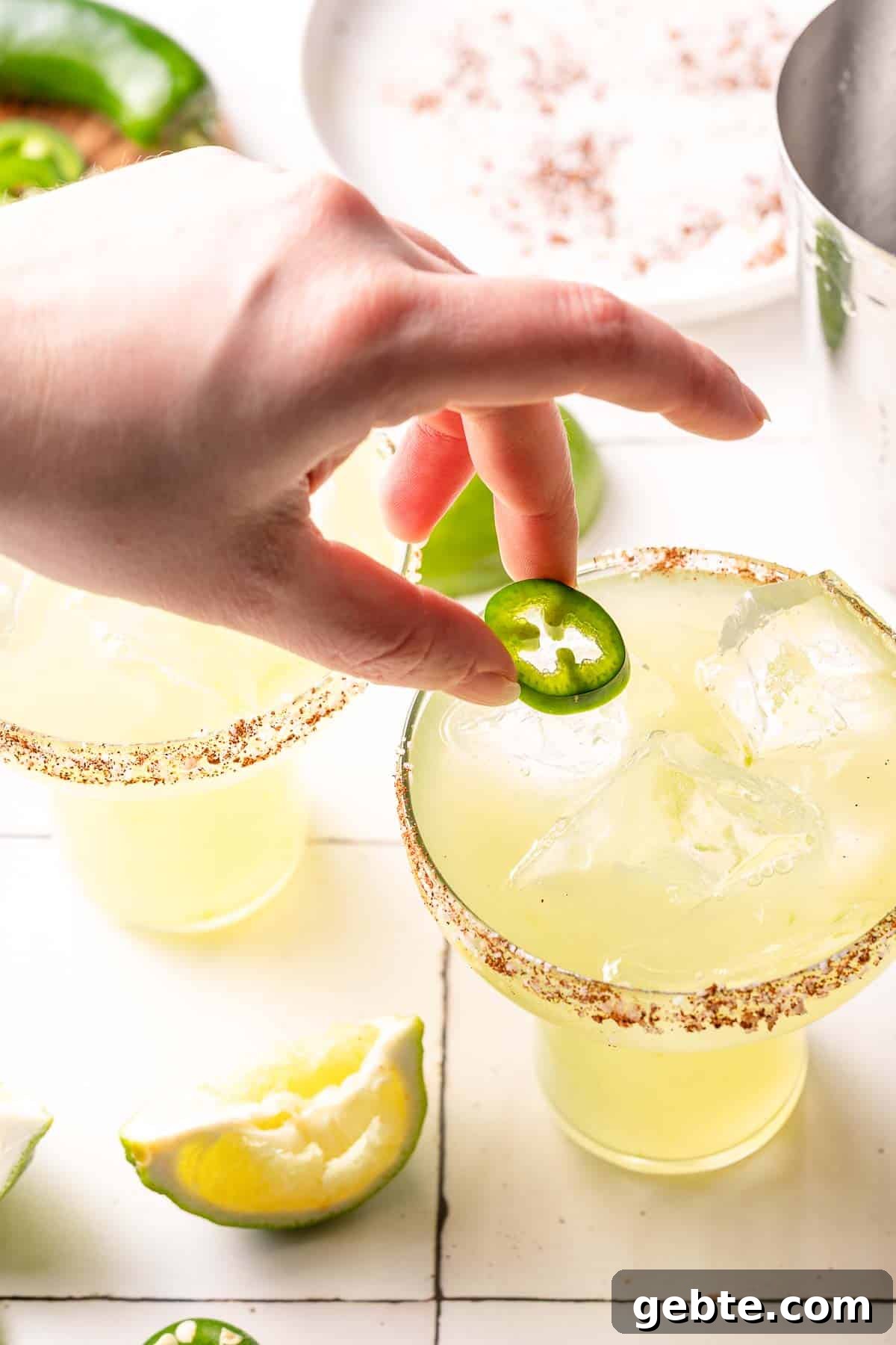 hand placing jalapeño garnish on spicy margarita