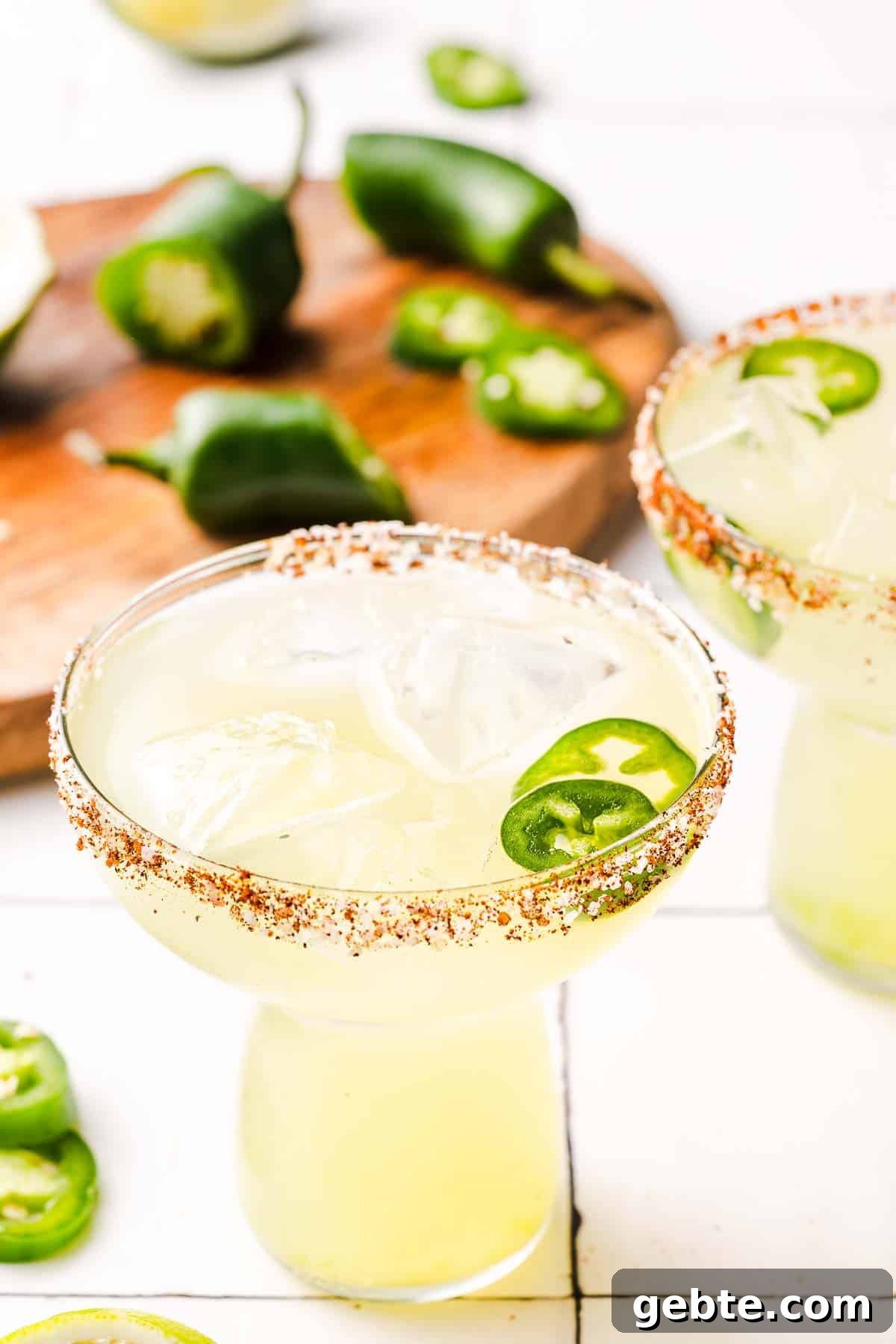 spicy margaritas with jalapeños in the background