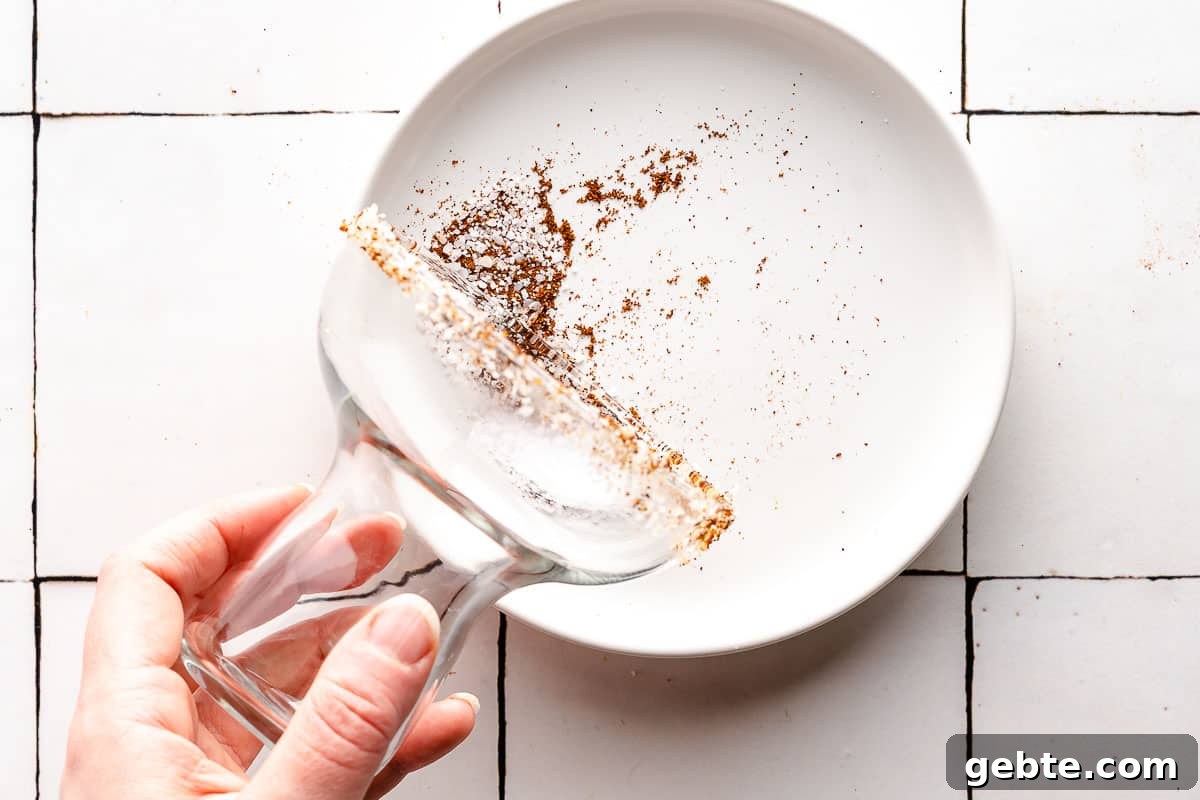 glass rim being tapped into chipotle salt mixture