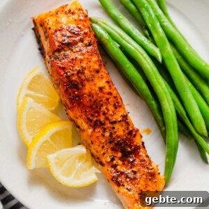 air fried salmon with green beans and lemon wedges.
