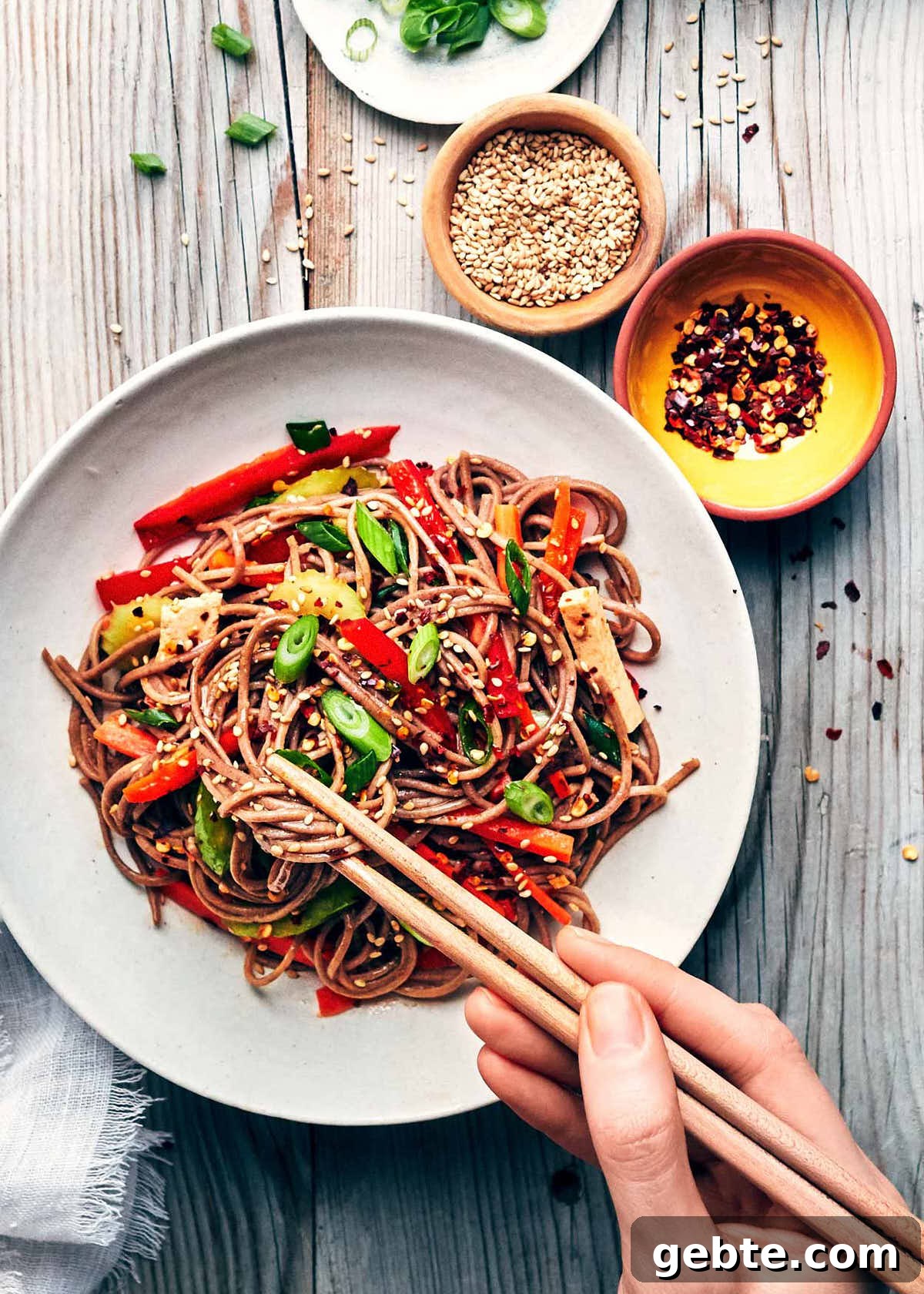 Digging into sesame soba noodle salad with chopsticks