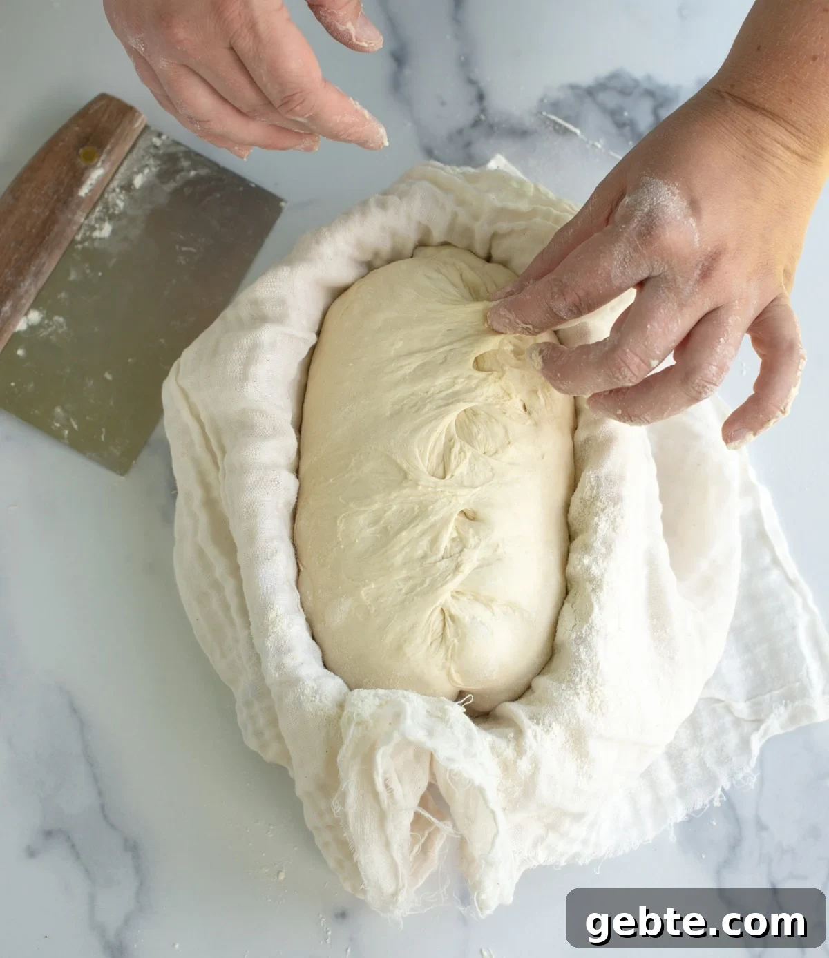 Sourdough Schedule for Beginners: Fit Baking into Your Daily Routine 4 Dough being shaped and put in a basket on a counter.