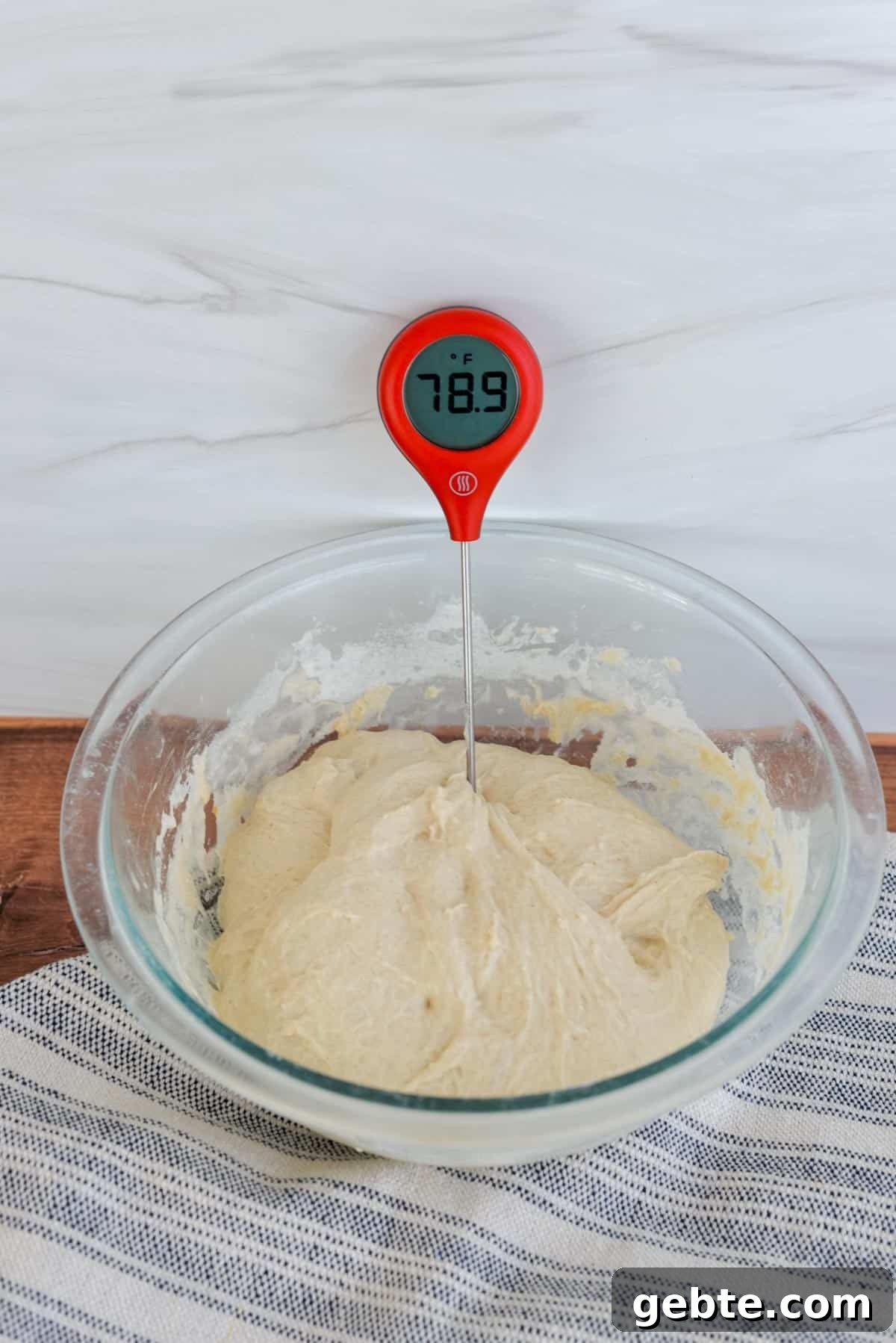 Sourdough Schedule for Beginners: Fit Baking into Your Daily Routine 6 Sourdough dough in a bowl with a thermometer sticking out of it on a counter.