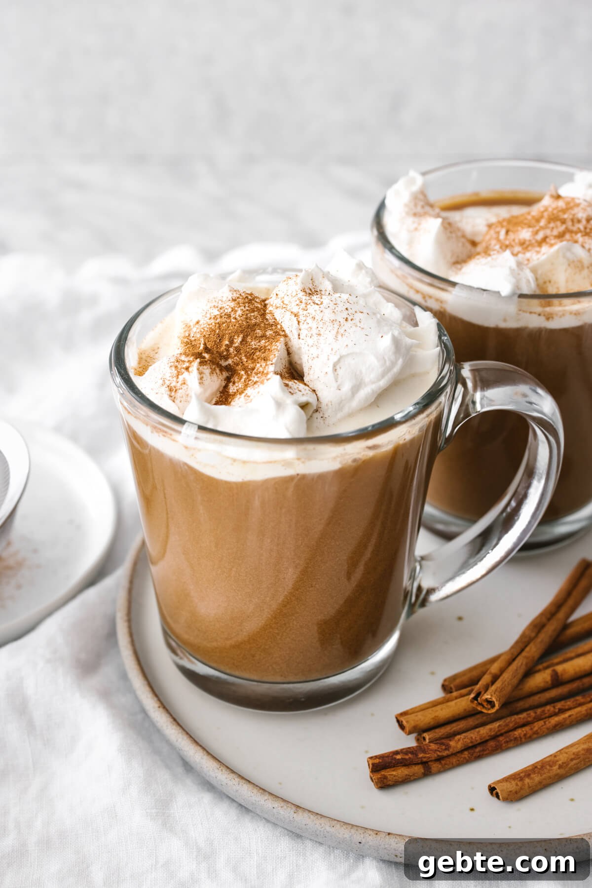 Two cups of pumpkin spice lattes on a plate.