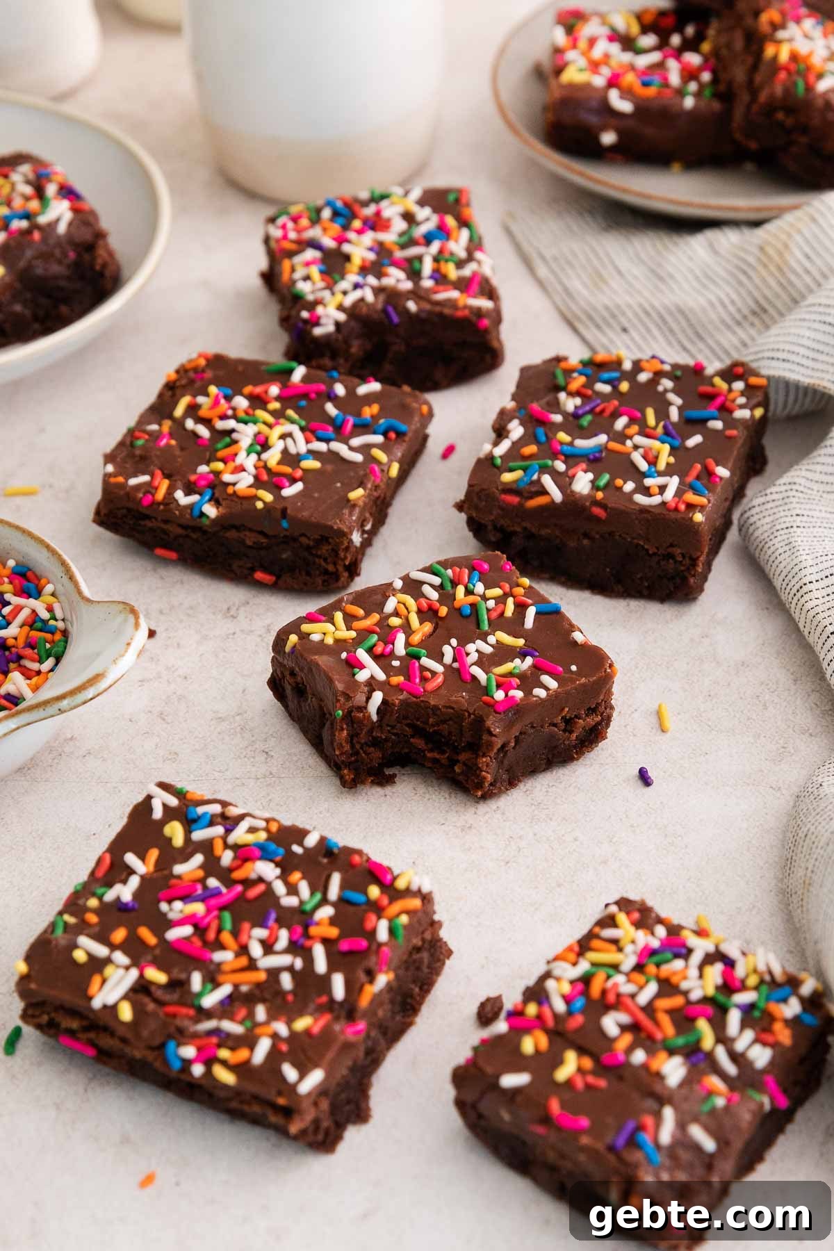 birthday brownies on a counter with a bite missing from one.
