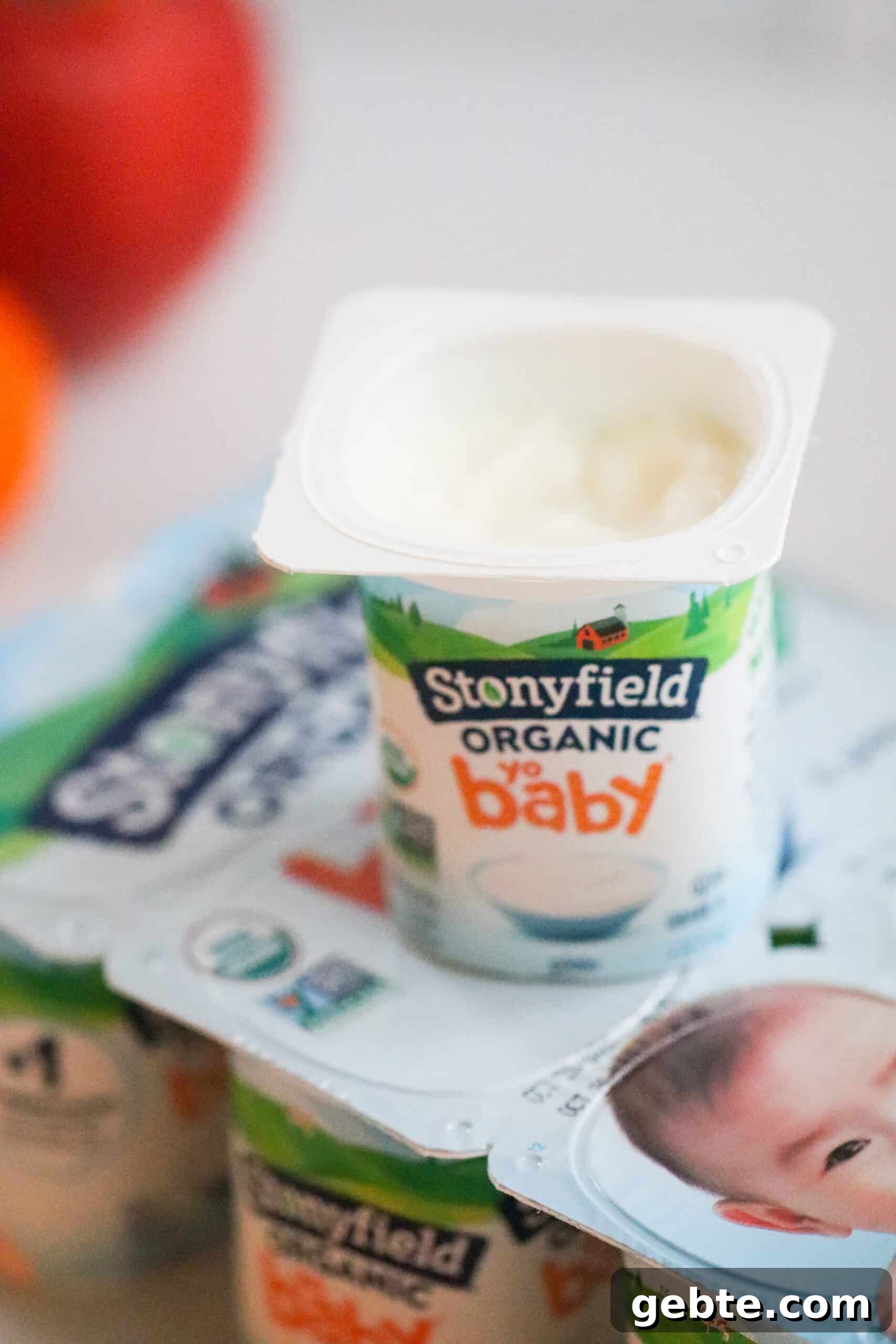 Package of stonyfield yogurts and one open on top
