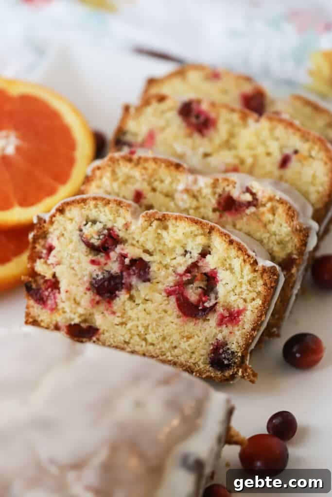 Cranberry Orange Quick Bread Recipe for Holiday Brunch 2 Glazed Orange Cranberry Bread sliced and topped with orange glaze, an easy quick bread recipe for the holidays.