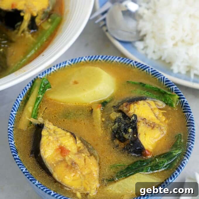 Sinigang na Hito sa Miso in blue bowl with a plate of steamed rice on the side