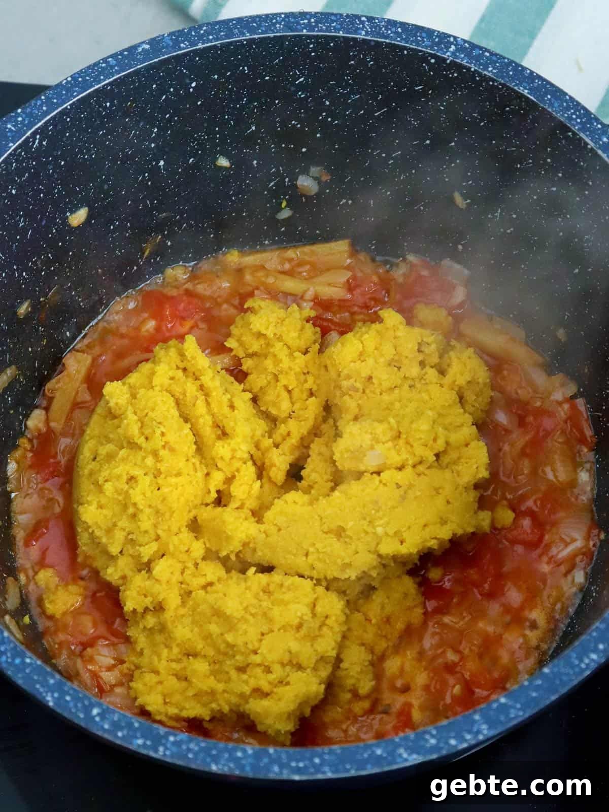 sauteing miso paste in pan with chopped tomatoes and onions