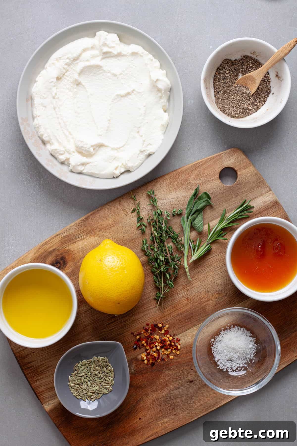 Ingredients for a whipped ricotta cheese dip on a gray table.