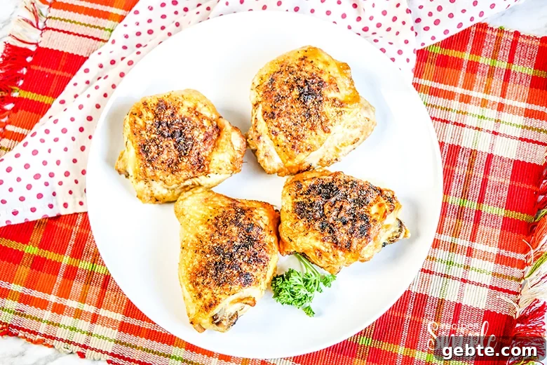 Crispy Air Fryer Chicken Thighs Recipe in 25 Minutes 3 Four Cooked Chicken Thighs on white plaid with red plain napkin