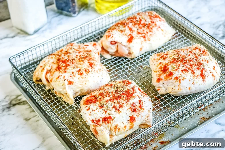 Crispy Air Fryer Chicken Thighs Recipe in 25 Minutes 4 Seasoned raw Chicken Thighs on Air Fryer Basket