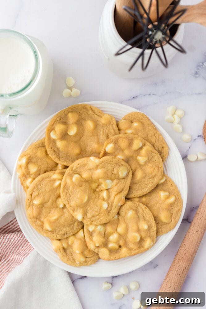 White chocolate chip cookies on a white plate.