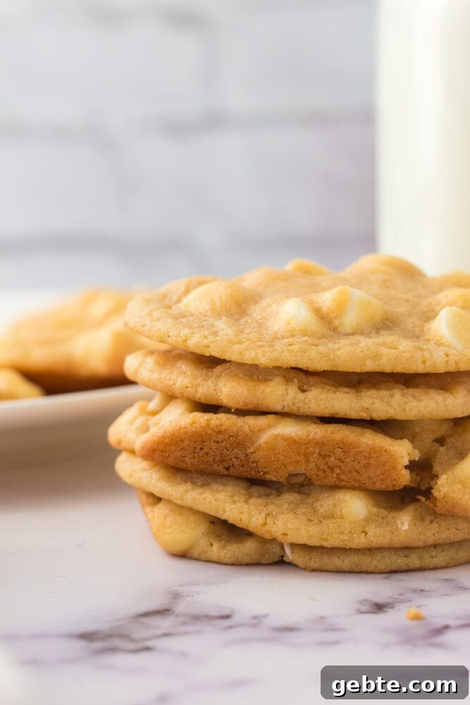 A stack of white chocolate chip cookies with a marble table.