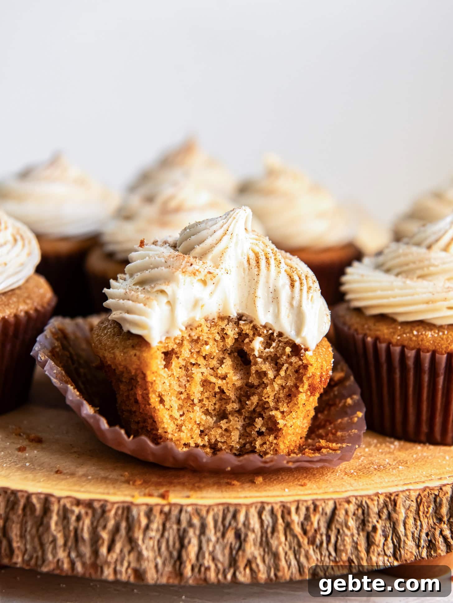 Maple Cream Cheese Frosted Spice Cupcakes 7 Spice cake cupcakes with a bite taken out of one.