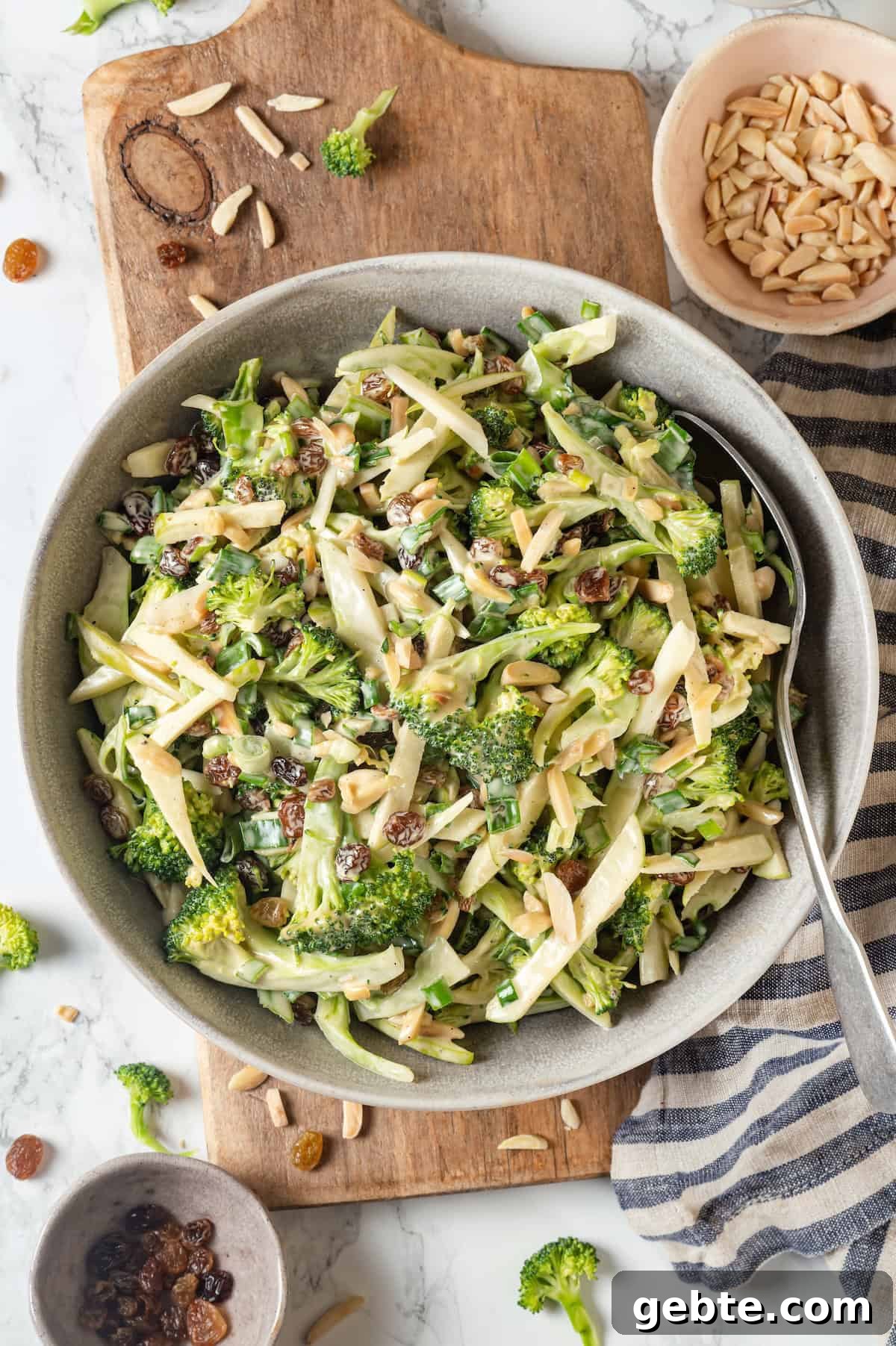 Overhead view of broccoli slaw in bowl with spoon