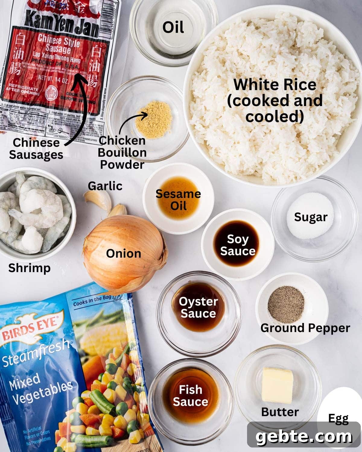 Ingredients needed for Vietnamese Fried Rice (com chien): white rice, Chinese Sausage, shrimp, mixed vegetables, onion, garlic, oil, chicken bouillon powder, sesame oil, soy sauce, oyster sauce, fish sauce, sugar, ground pepper, butter, and egg.