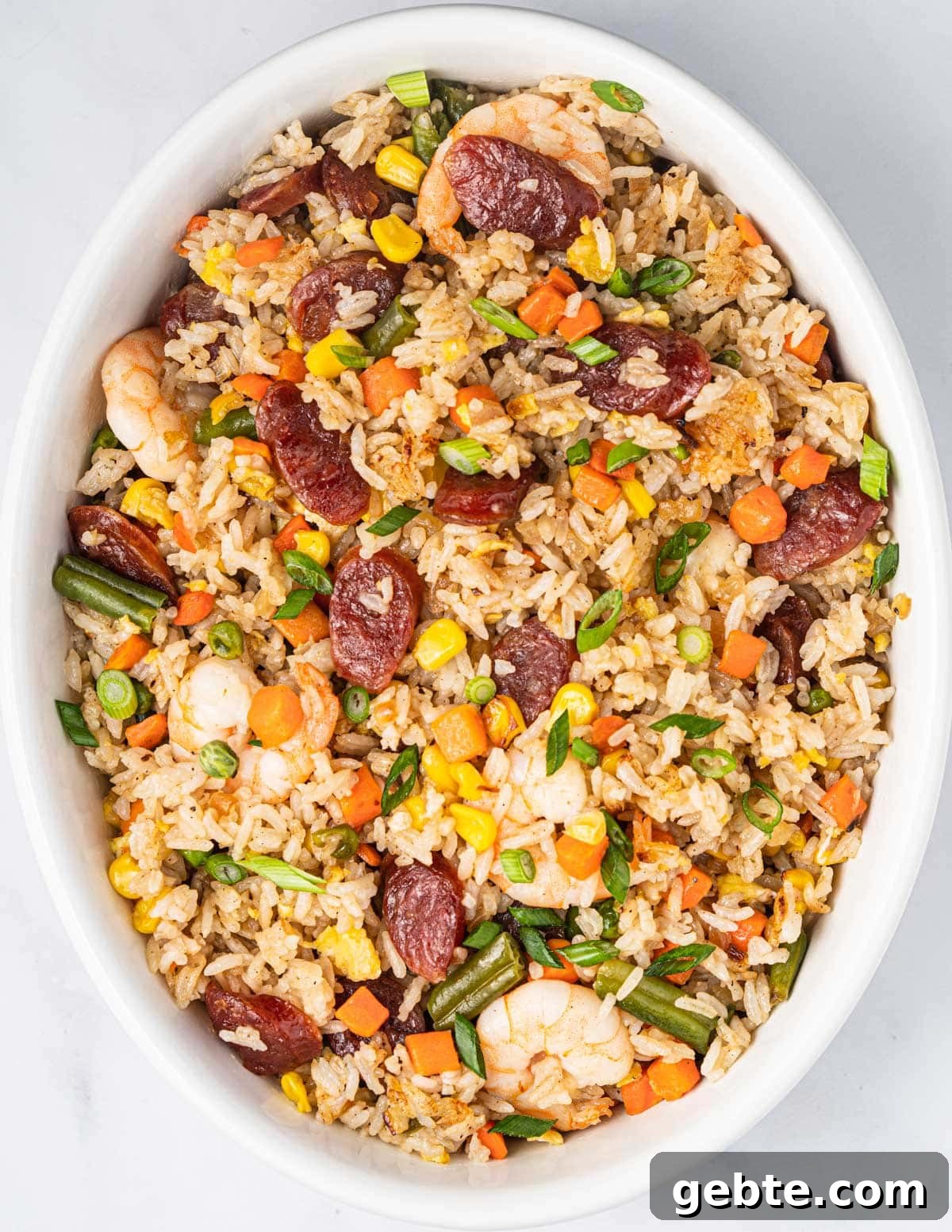 Serving bowl of Vietnamese Fried Rice with Chinese sausages, shrimp, and vegetables.