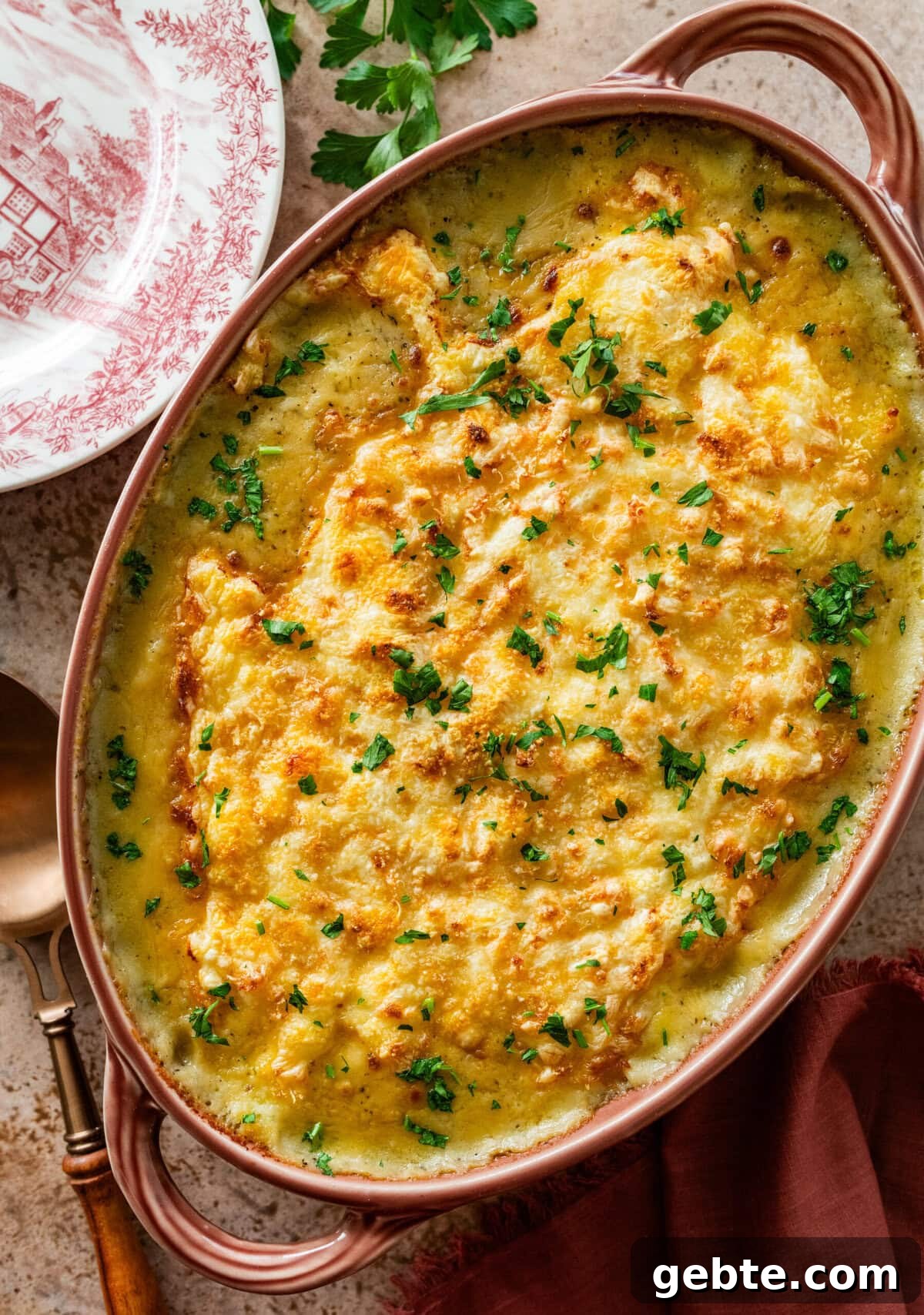 Hearty Turkey Shepherd's Pie Recipe for Comforting Weeknight Dinners 13 golden and bubble turkey shepards pie in a casserole dish with garnish of parsley on top.