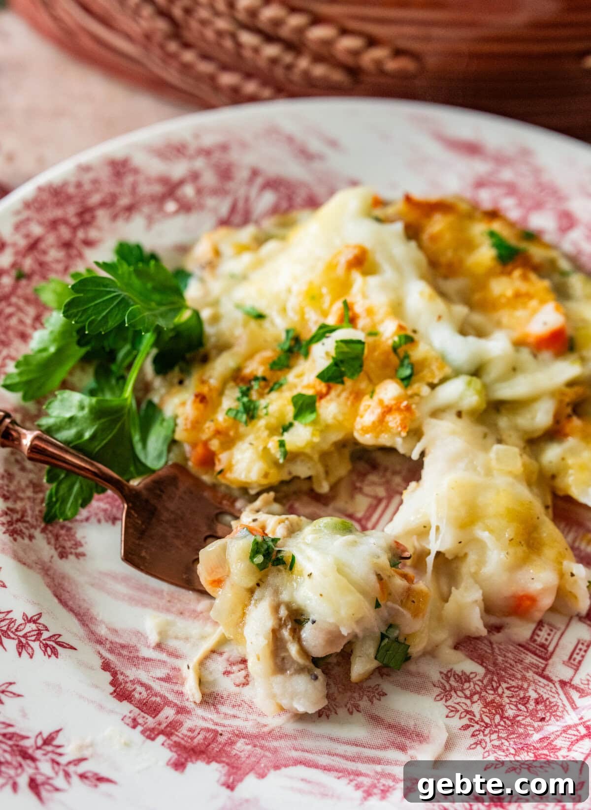 Hearty Turkey Shepherd's Pie Recipe for Comforting Weeknight Dinners 15 turkey shepards pie on a Thanksgiving plate with a fork taking a bite.