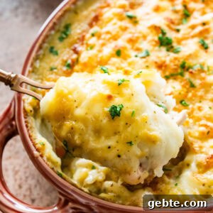 Hearty Turkey Shepherd's Pie Recipe for Comforting Weeknight Dinners 20 serving spoon dishing out a spoonful of turkey shepards pie from casserole dish.