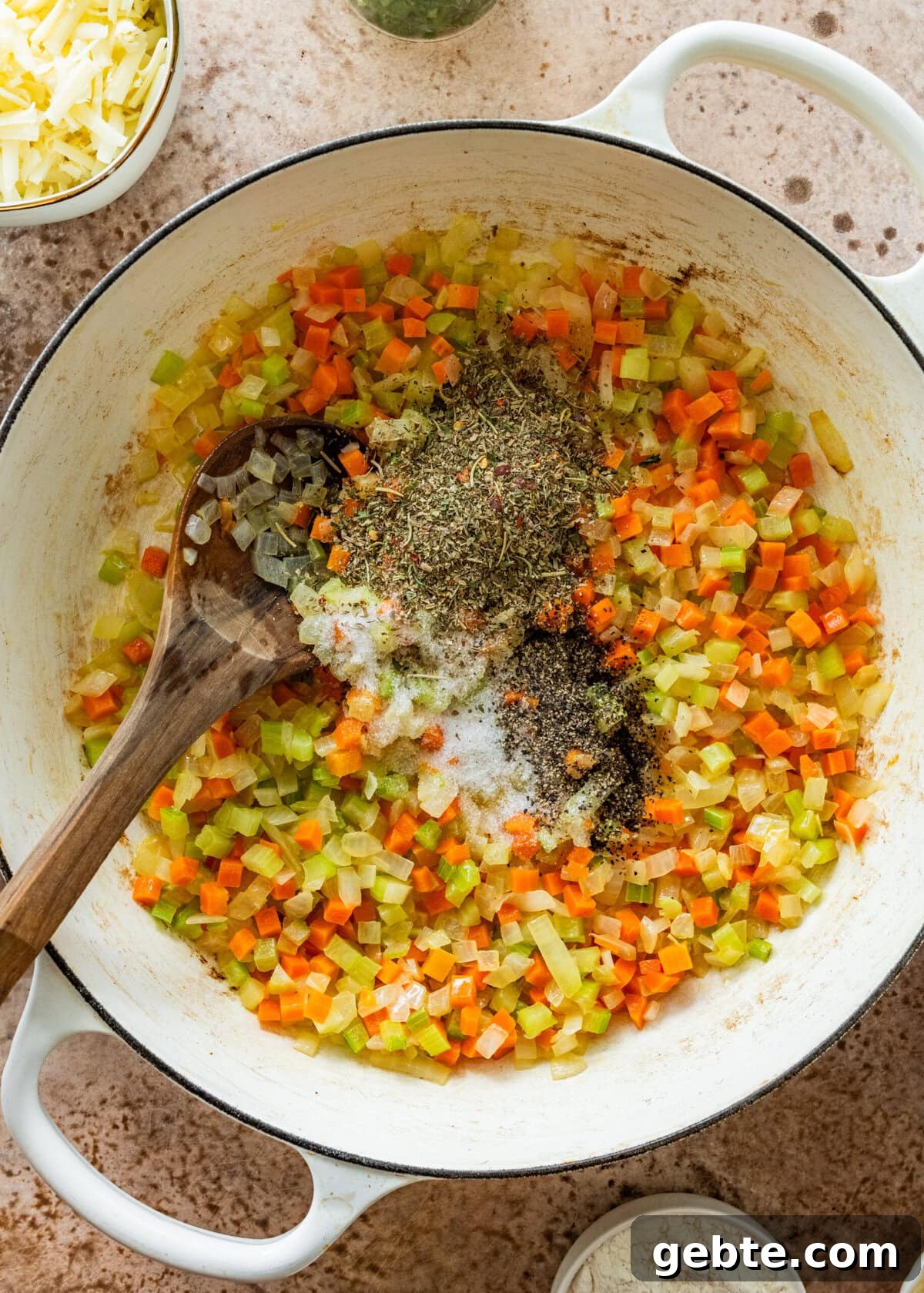 Hearty Turkey Shepherd's Pie Recipe for Comforting Weeknight Dinners 8 diced carrots, onions, and celery with spices in a pot.