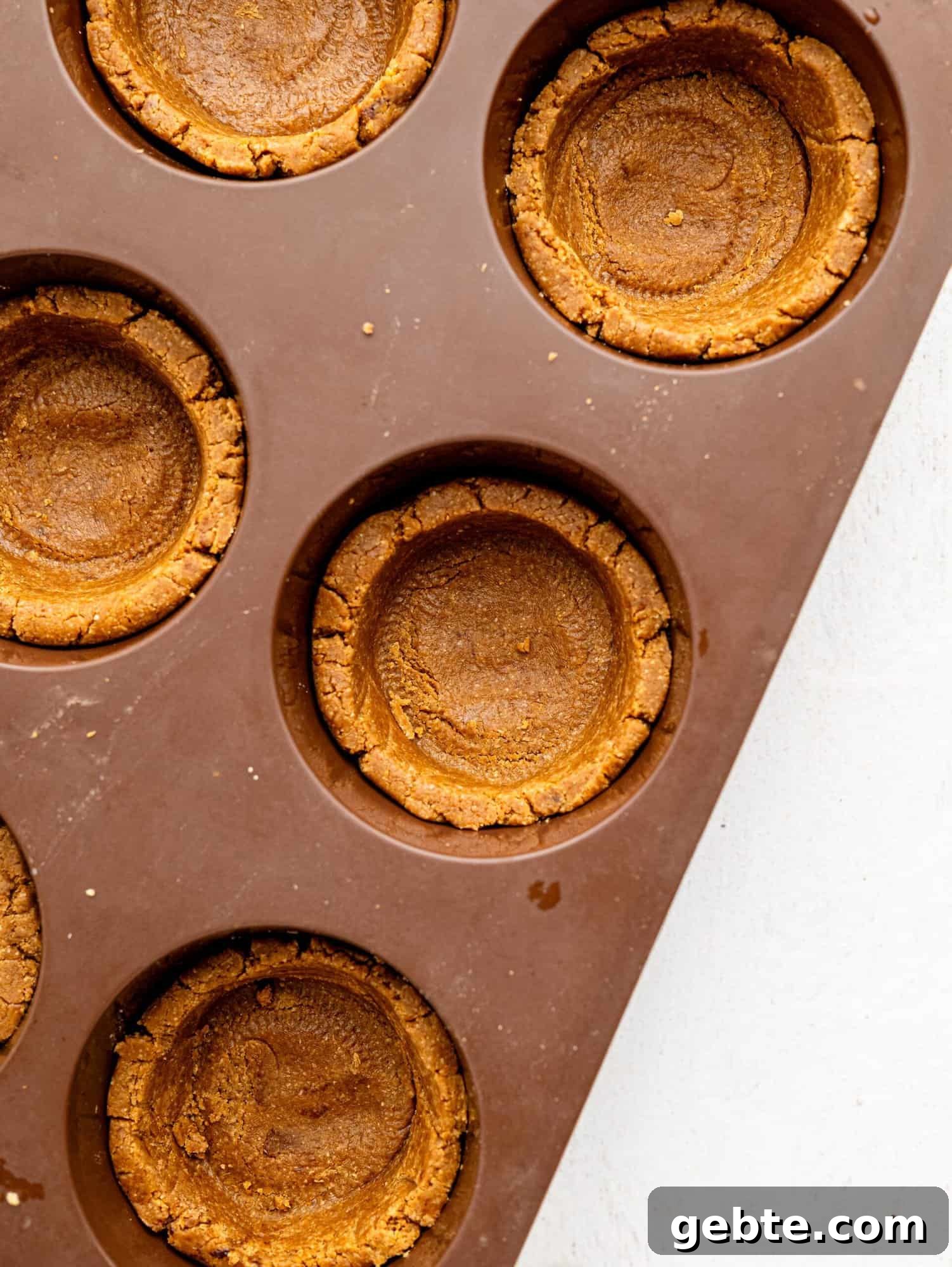 Coffee cookie dough pressed into a muffin tray.