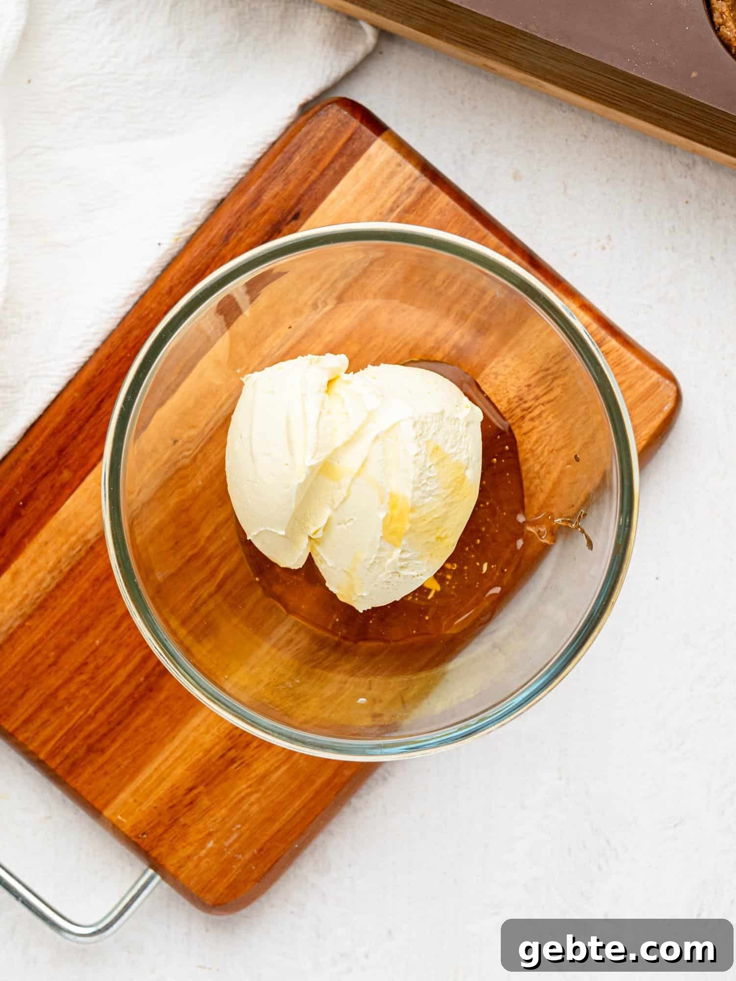 Cream cheese and honey in a glass bowl.