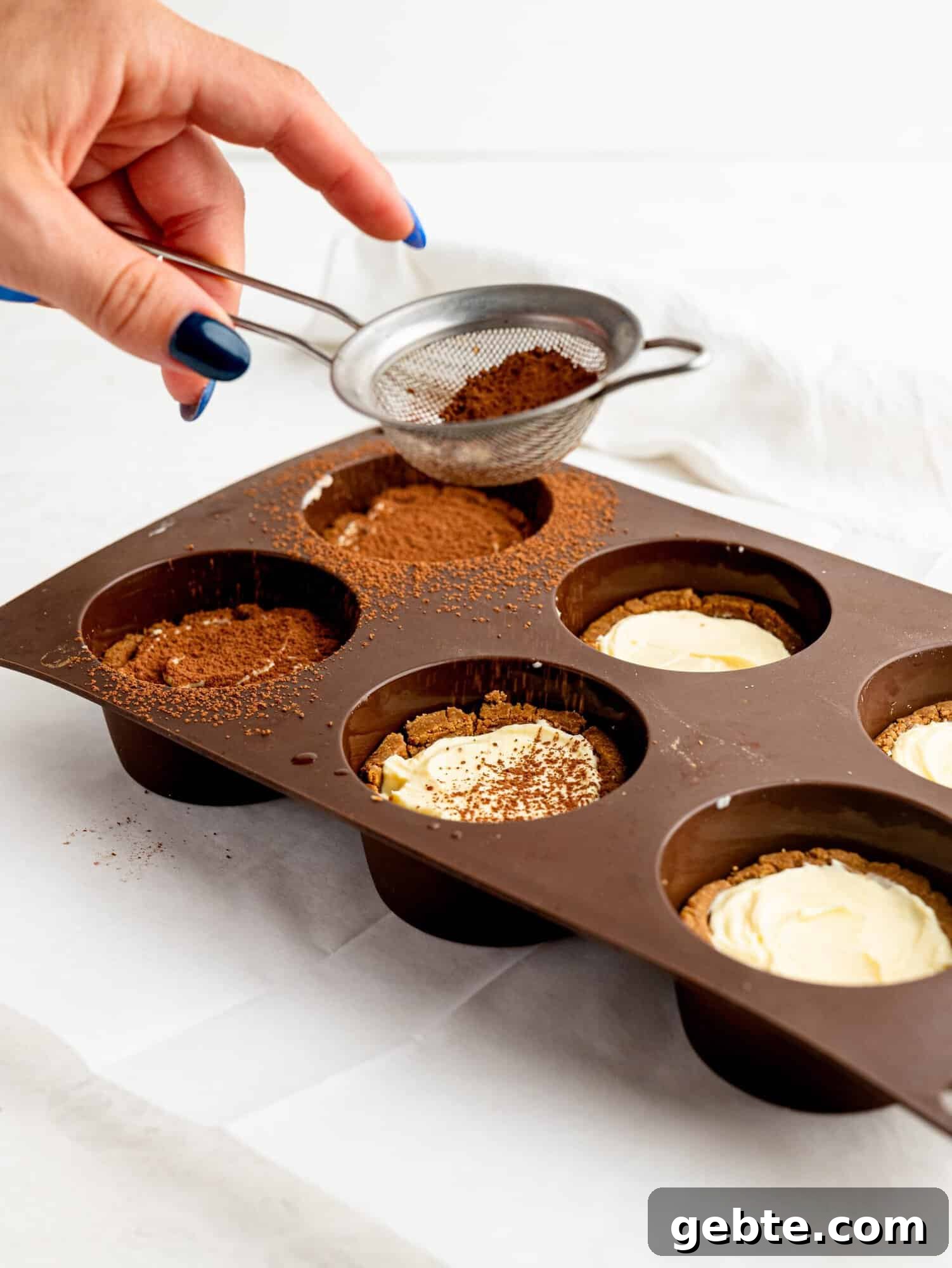 Dusting cocoa powder on tiramisu cookie dough cups.