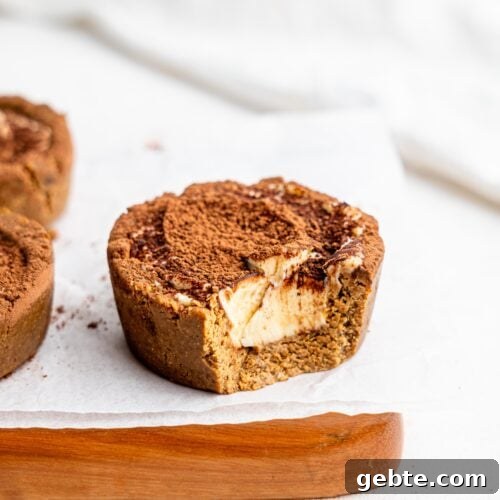A half-eaten Three Tiramisu cookie dough cup on a wooden board.
