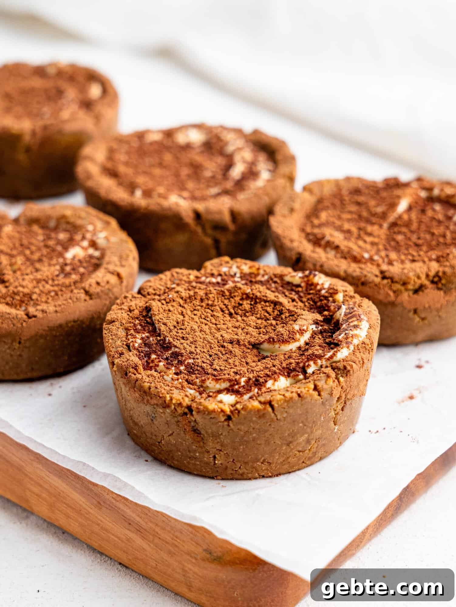 Tiramisu cookie dough cups on a wooden board.